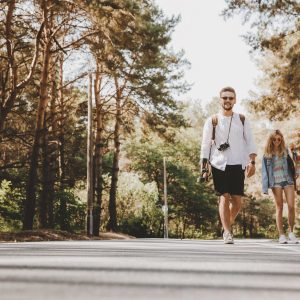 Loving couple walking with skateboards outdoors. ŽYGIS „PATIRK STICHIJAS PANEVĖŽYJE“